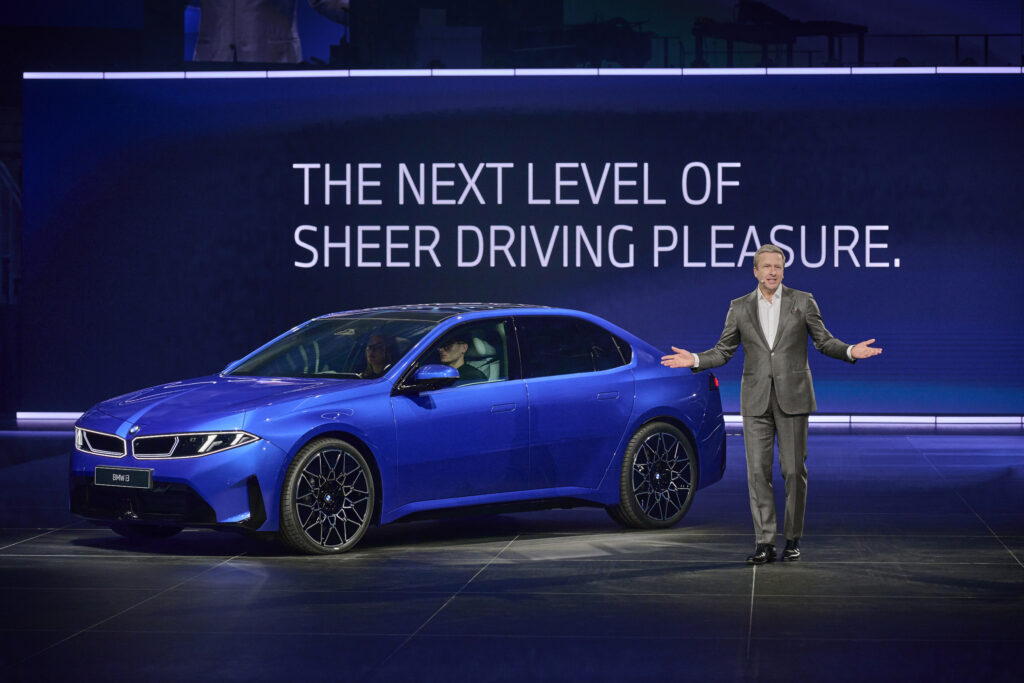 mann-im-anzug-steht-vor-blauem-bmw-i3