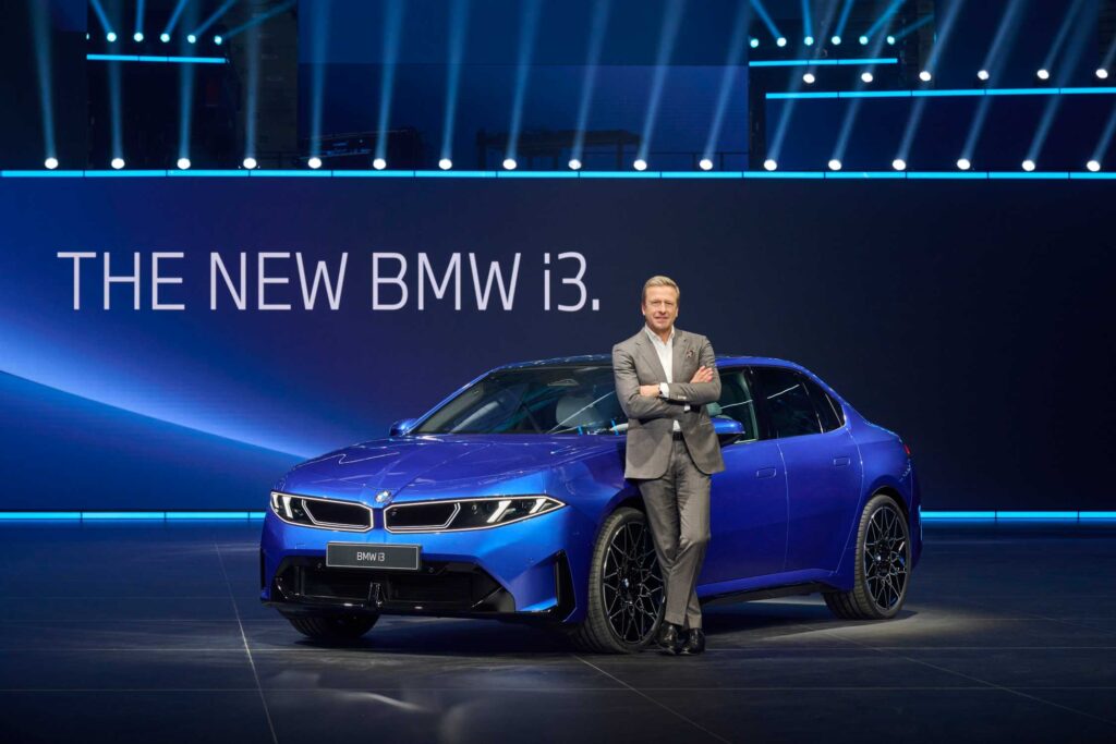 mann-in-grauem-anzug-steht-vor-neuem-bmw-i3-blau