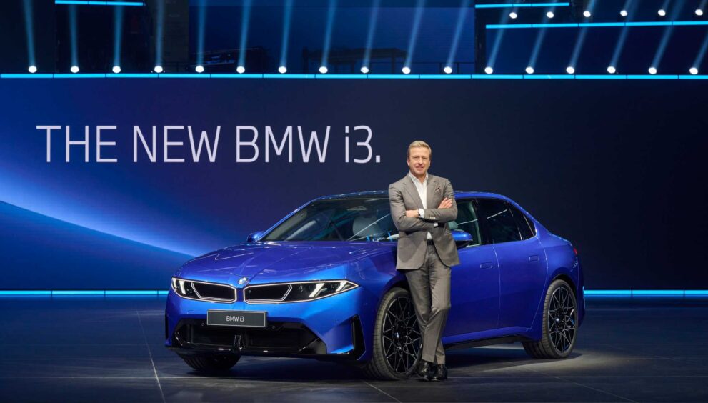 mann-in-grauem-anzug-steht-vor-neuem-bmw-i3-blau