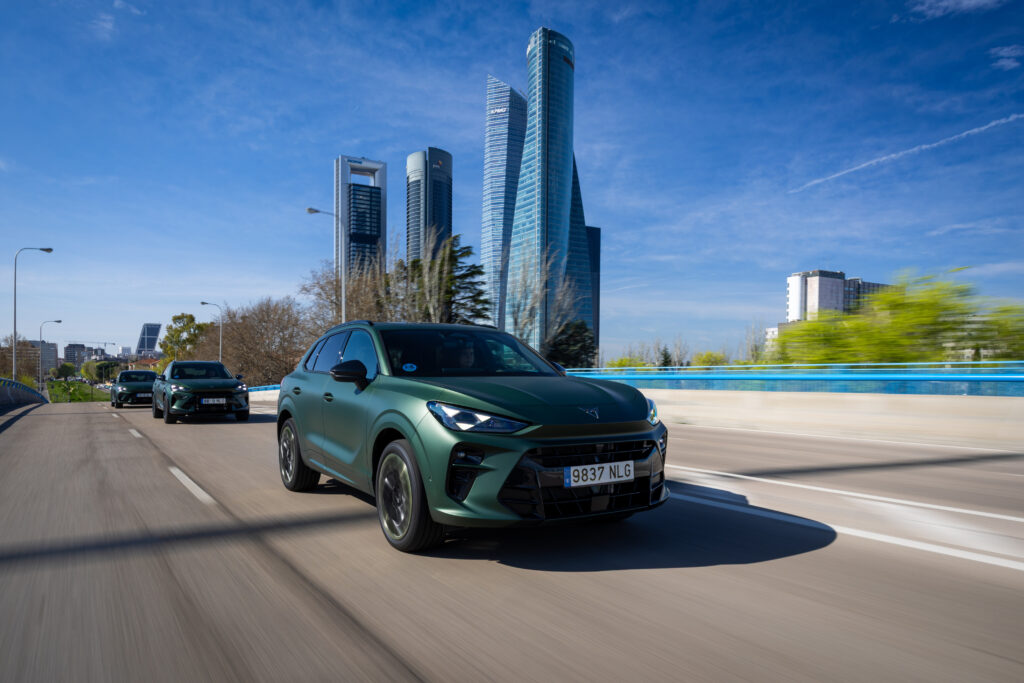 drei-olive-gruene-cupras-fahren-wolkenkratzer-im-hintergrund