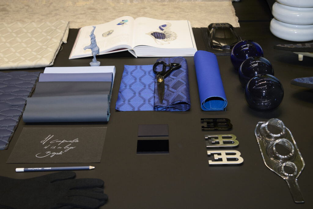 stoffe-schere-bugatti-logos-liegen-auf-tisch