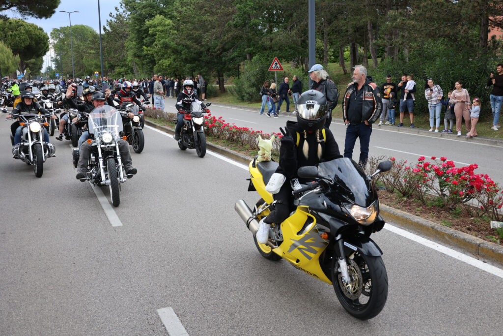 motorradgruppe-faehrt-auf-strasse-menschen-stehen-am-rand