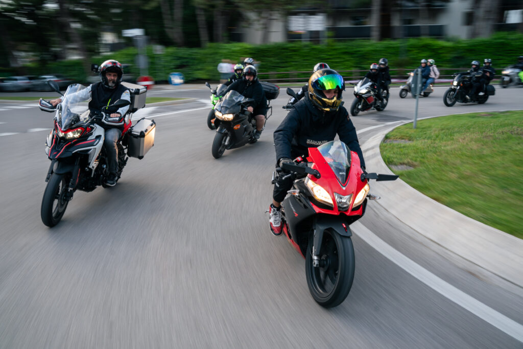 biker-gruppe-rotes-motorrad-vorne-faehrt-um-die-kurve