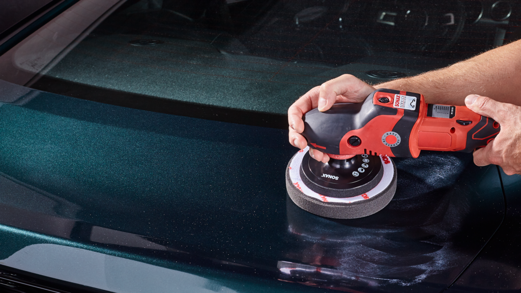 mann-poliert-auto-mit-rotem-geraet