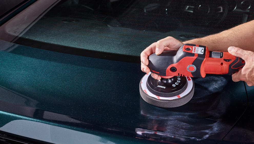 mann-poliert-auto-mit-rotem-geraet
