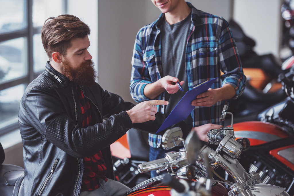 maenner-redev-ueber-motorrad-mit-blauem-block