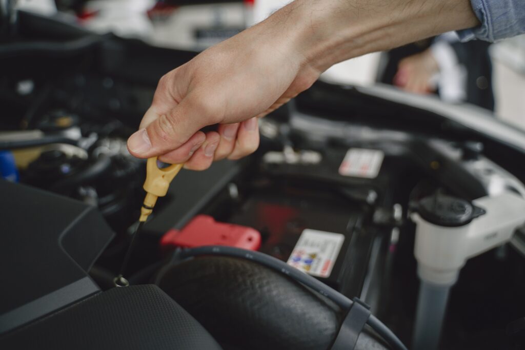 motorpflege-auto-mann-misst-oel